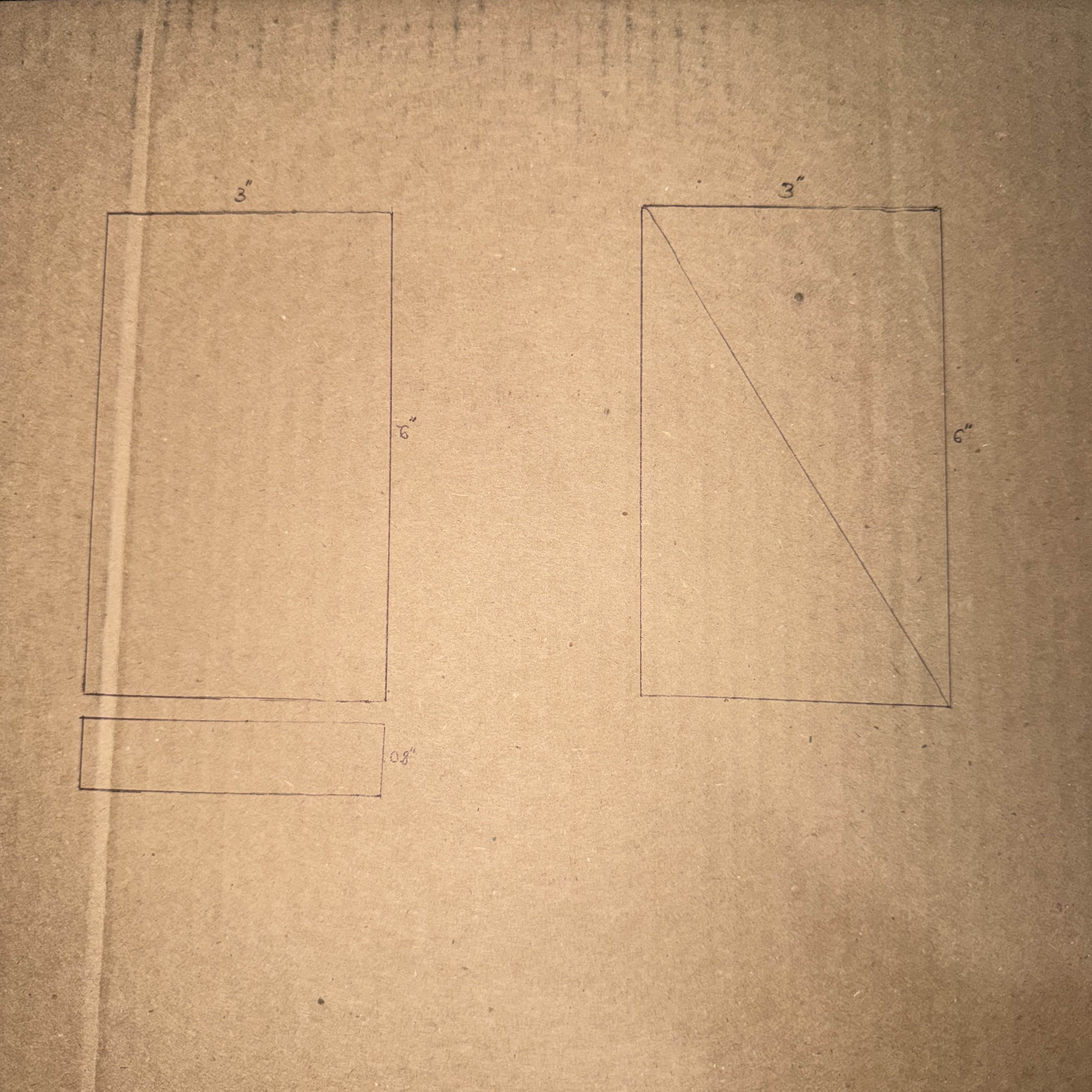 Initial sketch on cardboard marking the dimensions for the phone stand structure.